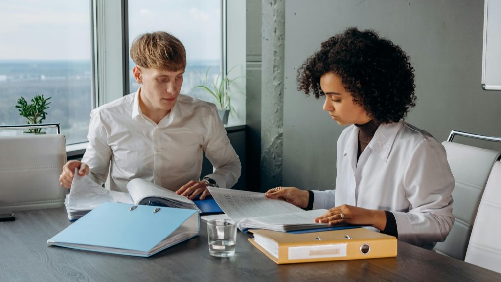 Shirts Sitting and Reading a Financial Report on a Conference Room